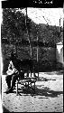 Man sitting on bench on patio, with dog standing on bench