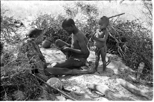 !Gai, Tsekue, and N!whakwe sitting at their place in the werft