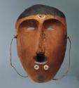 Dance mask. Male figure with ivory labrets. Crescent-shaped inlay of ivory.