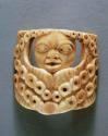 Ivory charm; human face with design of small circles