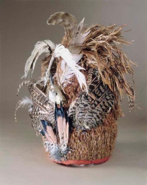 Conical cedar bark hat, woven and trimmed with feathers.