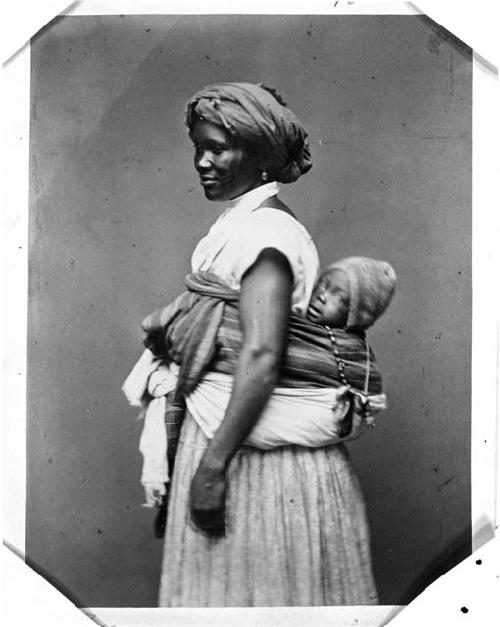 Portrait of woman with child strapped to back