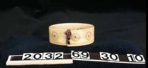 Bracelet made of antler, with circle and dot design. Iron inset in holes of dots