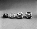 Miniature wrapped twined grass baskets with lid; twined bowl-shaped grass basket with lid; coiled miniature globular bowl of black horse hair with lid; coiled miniature globular bowl of white horse hair with lid.