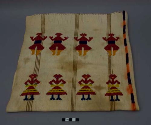 Textile, two panels sewn together, tan vertical stripes, red, blue, and orange human form brocade. The white has darkened over time and is heavily stained. There is a small hole in the lower left corner.