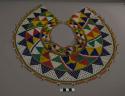 Beaded collar, red, orange, yellow, blue, green, and white triangles arranged in a circular design. Some areas of beading are missing, broken threads, and dirt (particularly visible on white and yellow beads).