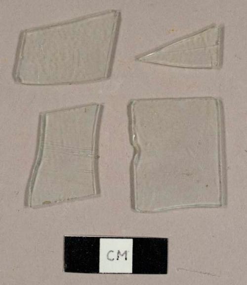 Colorless flat glass fragments, two fragments with a series of parallel lines etched into one side