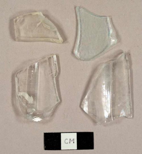 Colorless bottle glass fragments, including two faceted fragments possibly from a tumbler and one piece from a hurricane lamp