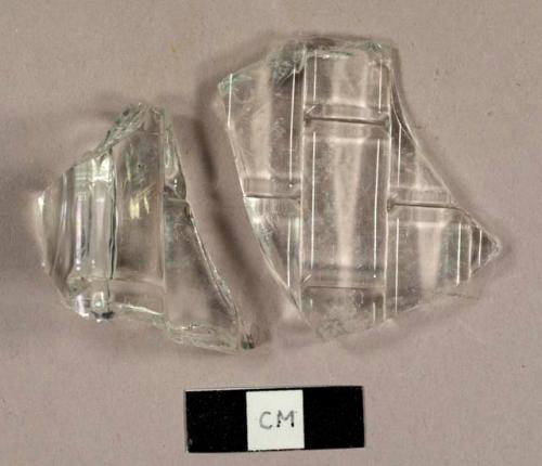 Colorless glass fragments from a rectangular bottle with molded brick pattern