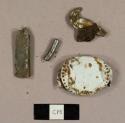 Metal debris, including a pot top, crown bottle cap, and folded rectangle of lead