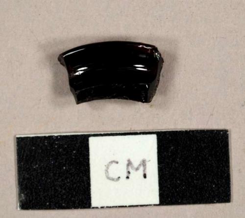 Purple curved glass fragment, possibly a lid