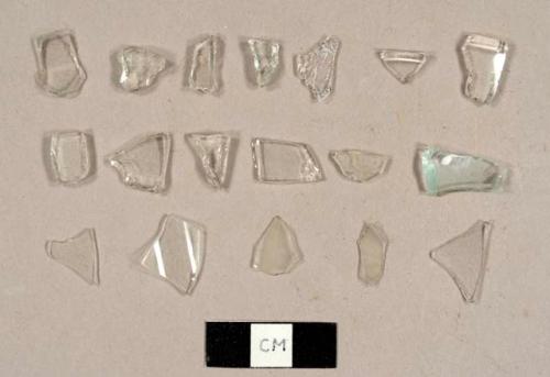 Colorless curved glass fragments, including five fragments from a hurricane lamp and two rims for cups