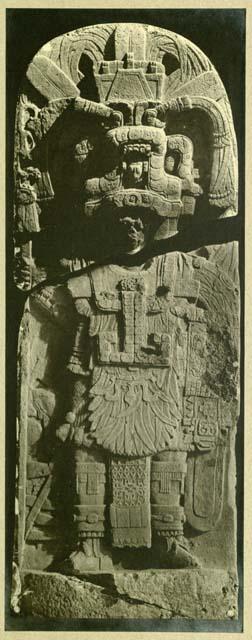 Stela 7 broken in two pieces, showing warrior of high rank holding a lance and shield