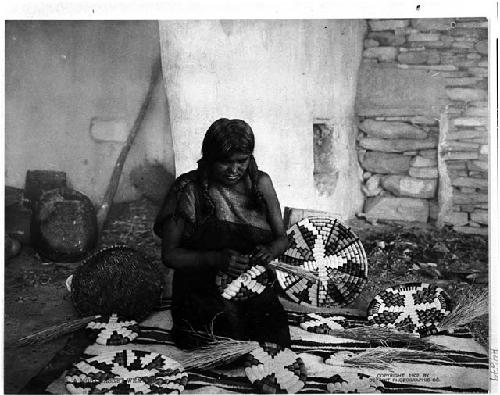 Woman weaving plaque and baskets