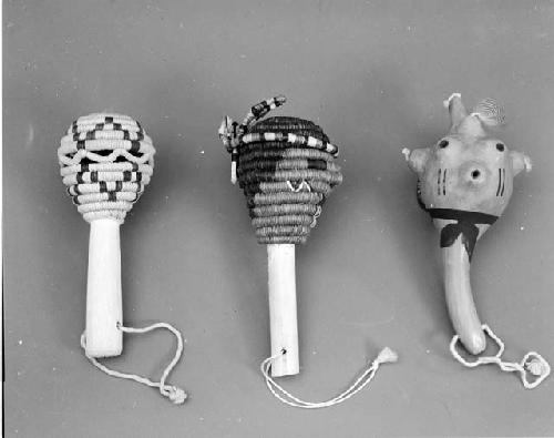 Coiled rattle with yellow diamond motif; coiled rattle of Navajo kachina; black-on-red mudhead rattle; large gourd rattle in form of black creature; gourd rattle with feathers; gourd rattle with turtle motif