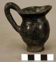 Ceramic miniature pitcher, black burnished exterior, flared oblong lip
