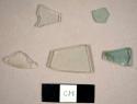 Glass fragments, including two aqua flat glass fragments, two colorless flat glass fragments, and one colorless curved glass fragment