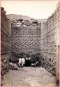 Men and a woman inside structure at Mitla