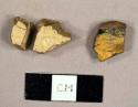 Miscellaneous earthenware sherds, including two yellowware sherds that mend together and one lead glazed redware sherd with slip decorated exterior and solid black interior