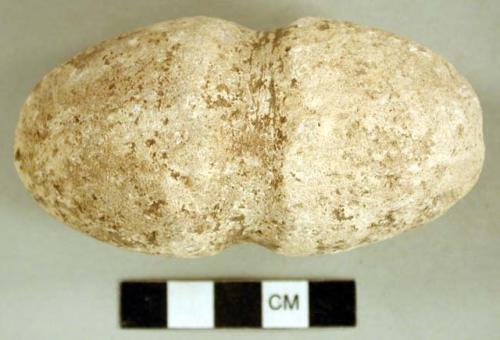 Ground stone, ovoid stone with groove around the center, incised X at one end