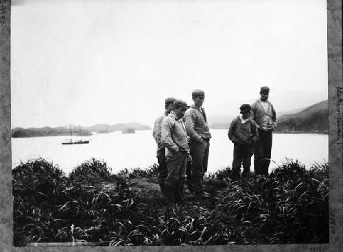 Aleutian men standing near water in European clothing
