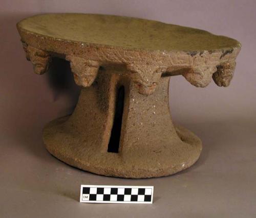 Circular metate with heads of an animal around the edge on the under side