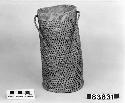 Cylindrical basket with cord handle from the collection of Lt. Woodworth, ca.1878. Plain, open-twined; crossed warps.