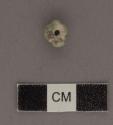 Small decorated jadeite bead, chipped - 7.2x9x5.2 mm.
