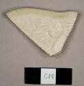 White salt-glazed molded stoneware rim sherd from a plate with the "dot, diaper, basket" pattern and a scalloped edge