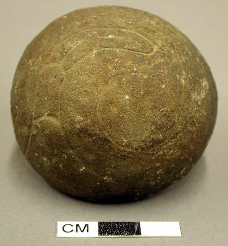 Ground stone sphere, incised decoration, chip off of one side, burned.