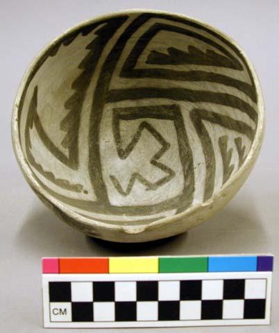 Ceramic bowl, black & white interior design, rim sherds missing.