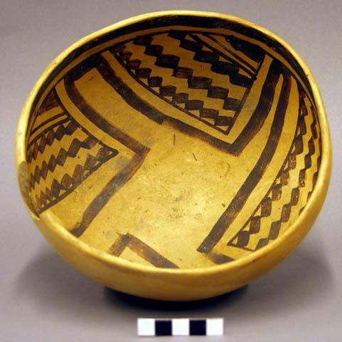 Ceramic bowl, brown on yellow interior, chipped rim
