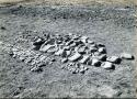 Scan of photograph from Judge Burt Cosgrove photo album. Pendleton Ruin. Manos,rubbing, stones, metates and mortor.