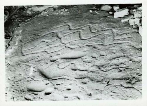 Scan of photograph from Judge Burt Cosgrove photo album.Deep Indian pelroglyphs in floor of cave Saddle Mt. Catron Co N.Mex 10-26-30