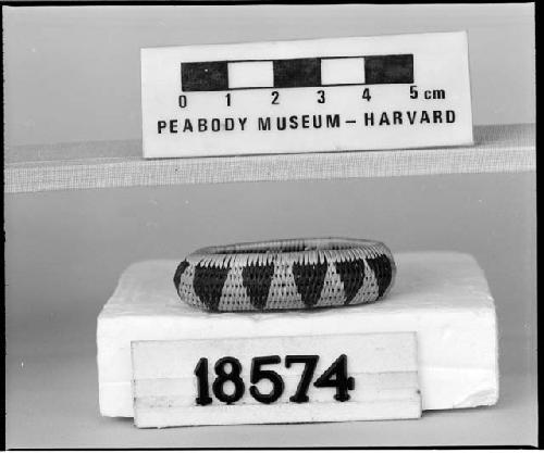 Miniature oval basket from the collection of the brothers of Mrs. J.M. Robinson, 1883-1925. Coiled, interlocking stitches, one rod.