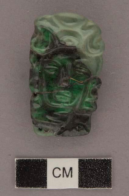 Portion of carved jadeite ornament, human face