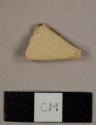 Yellow/buff bodied earthenware sherd with no remaining glaze