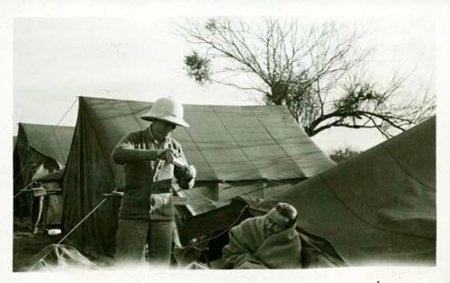 Scan of photograph from Judge Burt Cosgrove photo album.Ted Amsden C.B.C.Jr "Giving aid to poor boy injured when his house fell in"