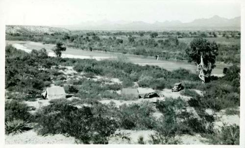 Scan of photograph from Judge Burt Cosgrove photo album.Camp on Rio Grande River near the Chavez Cave Oct.4 to Oct.21-1927. Dona Ana Mts. in bckground