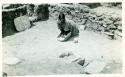 Scan of photograph from Judge Burt Cosgrove photo album.Room 109 Ruined Pueblo on Swarts Ranch mimbres Valley New Mex. 1927. (Grinding Corn in the house of her ancestors.)