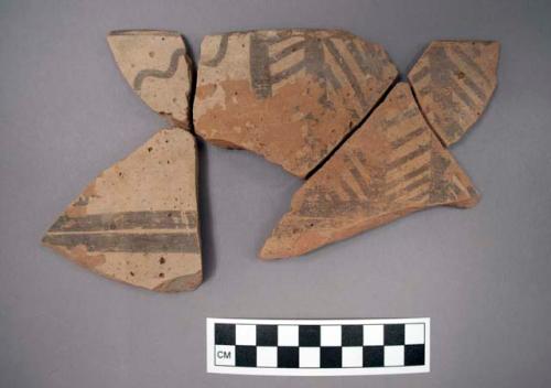 Ceramic sherds of a bowl, exterior has black designs on buff