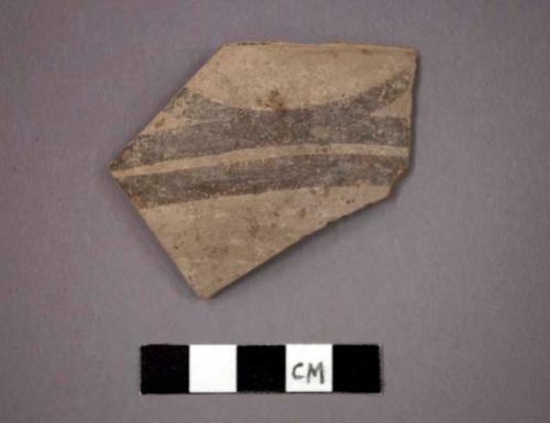 Ceramic rim sherd from bowl, black painted designs both sides