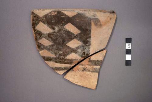 Ceramic sherds of bowl, black painted designs on exterior, will mend together