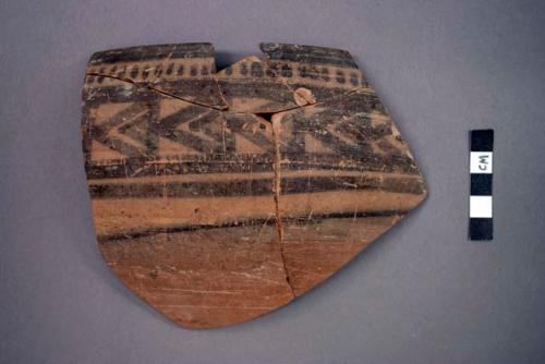 Ceramic rim sherd of bowl, black geometric designs both sides, mended