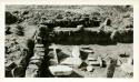 Scan of page from Judge Burt Cosgrove photo album.Room 7 to west-Room 8 in background Bin and metate against south wall. Agate House