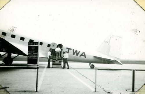 Scan of page from Judge Burt Cosgrove photo album.Burton entering plane for Albuquerque Kansas City Airport