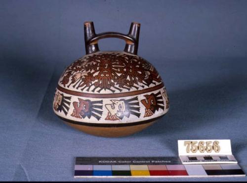 Double spout bottle painted in polychrome w/ 2 mythical beings and trophy heads