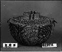 Bottleneck basket with red wool and feather decoration, from unknown collection. Coiled.