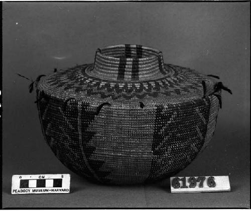 Bottleneck basket with red wool and feather decoration, from unknown collection. Coiled.