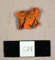 Orange plastic flagging tape fragment